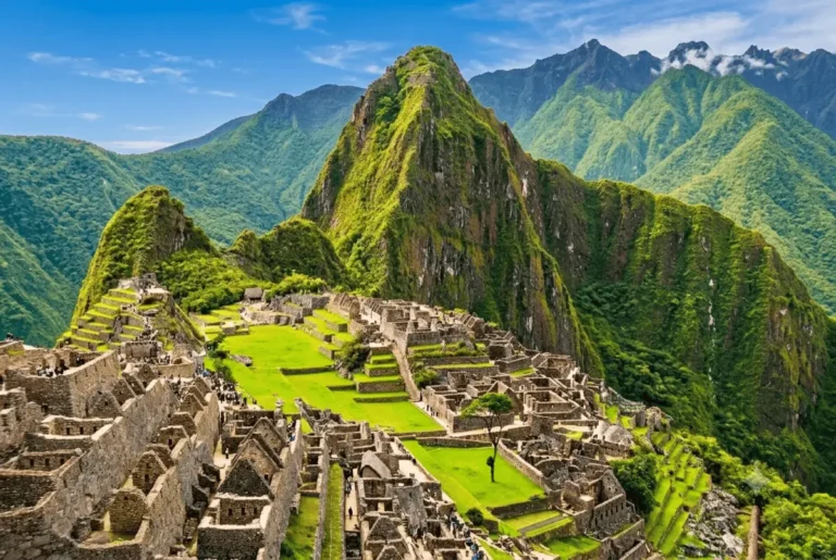 Panoramic view of the ancient Machu Picchu stone ruins and green terraces nestled between steep mountain peaks