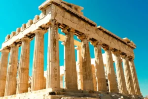 Low-angle view of the Parthenon temple columns at the Acropolis of Athens against a clear blue sky