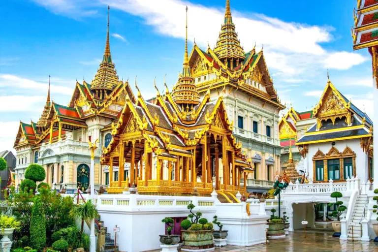 Grand facade and golden spires of The Grand Palace in Bangkok, showcasing traditional Thai architecture and cultural heritage.