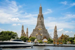 Majestic Wat Arun - Temple of Dawn towering over the Chao Phraya River in Bangkok, Thailand.