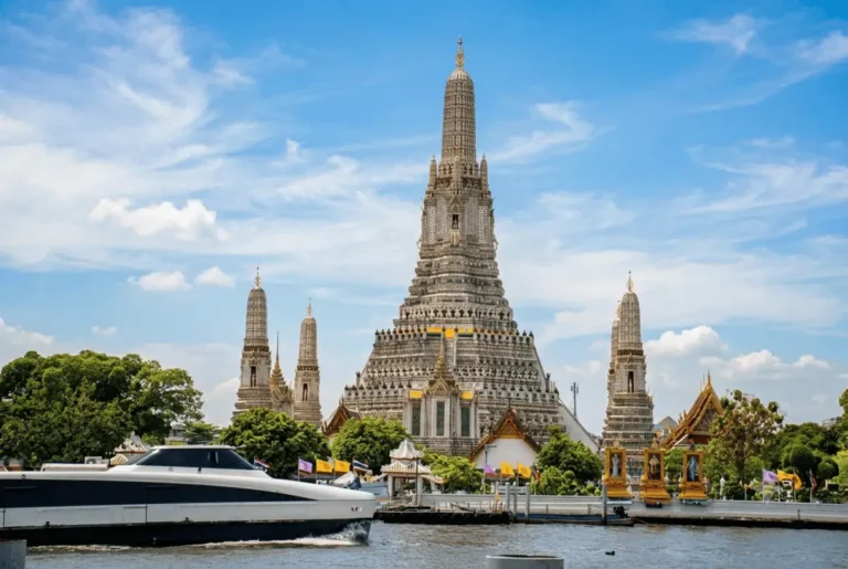 Majestic Wat Arun - Temple of Dawn towering over the Chao Phraya River in Bangkok, Thailand.